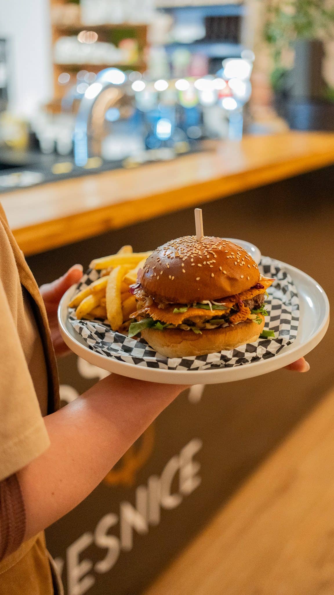 Burger s hranolky servírovaný na baru